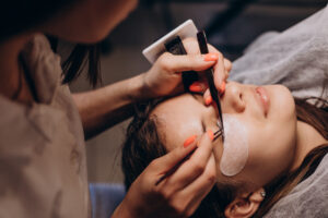 Lash technician performing a lash lift treatment on a client